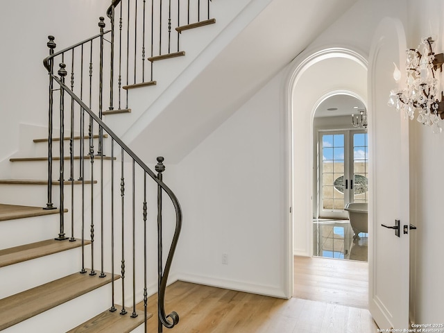 staircase with hardwood / wood-style flooring and french doors