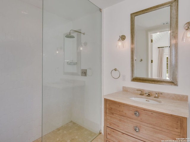 bathroom with vanity and a tile shower