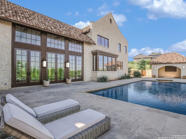 view of swimming pool with a patio area and french doors