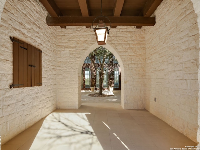 hall with tile patterned flooring, wood ceiling, and beamed ceiling