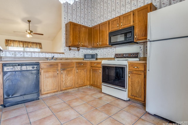 kitchen featuring lofted ceiling, sink, light tile patterned floors, ceiling fan, and black appliances