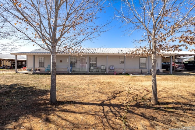 view of front of home with a front yard and a carport