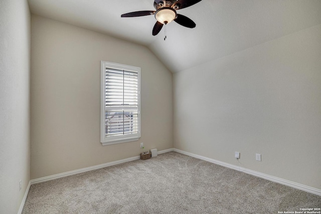 carpeted spare room featuring a ceiling fan, lofted ceiling, and baseboards