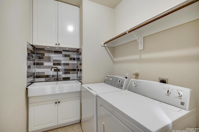 clothes washing area featuring a sink, light tile patterned floors, washing machine and dryer, and cabinet space