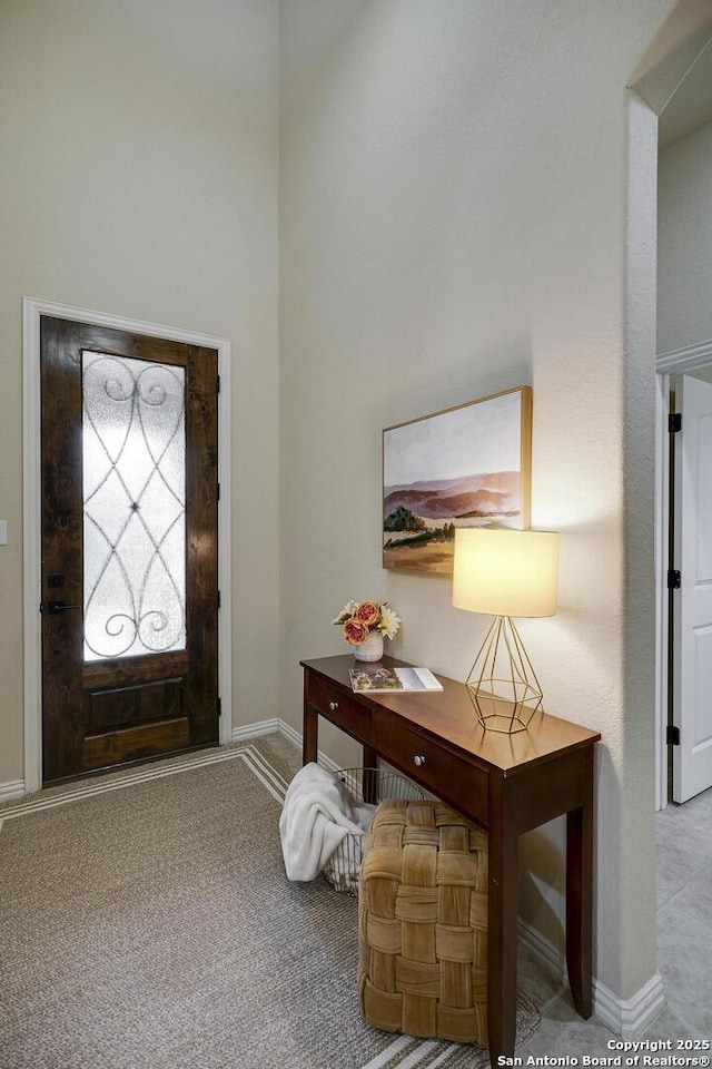 foyer entrance featuring carpet flooring and baseboards