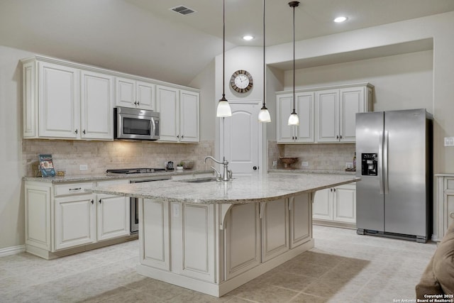 kitchen with stainless steel appliances, visible vents, hanging light fixtures, a sink, and light stone countertops