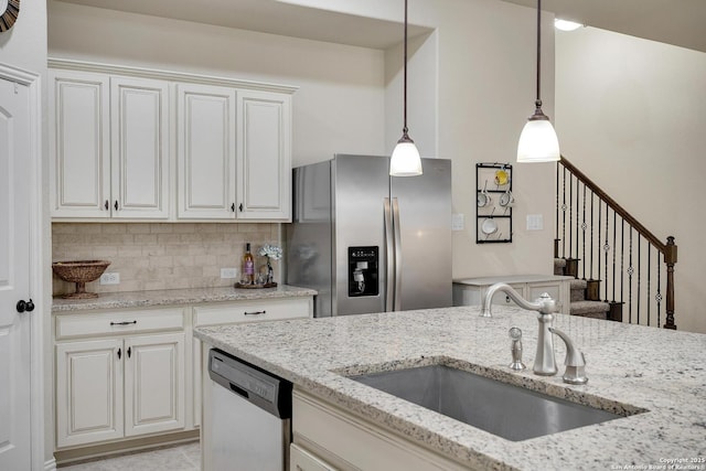 kitchen with light stone counters, decorative backsplash, stainless steel appliances, and a sink