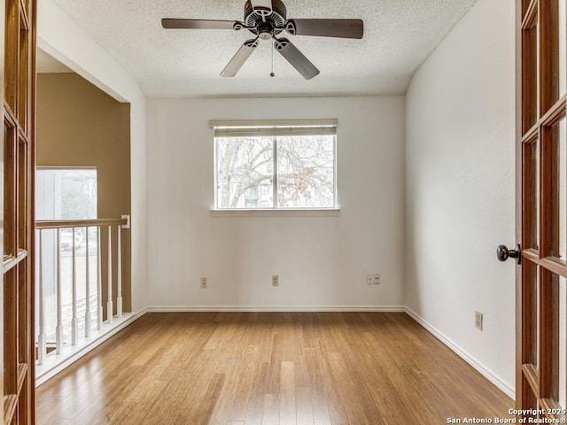 spare room featuring a textured ceiling and light hardwood / wood-style flooring