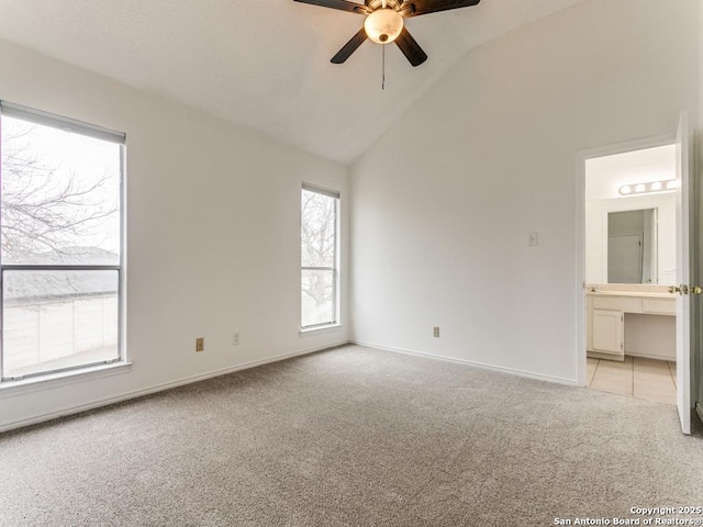 spare room featuring ceiling fan, light colored carpet, and high vaulted ceiling