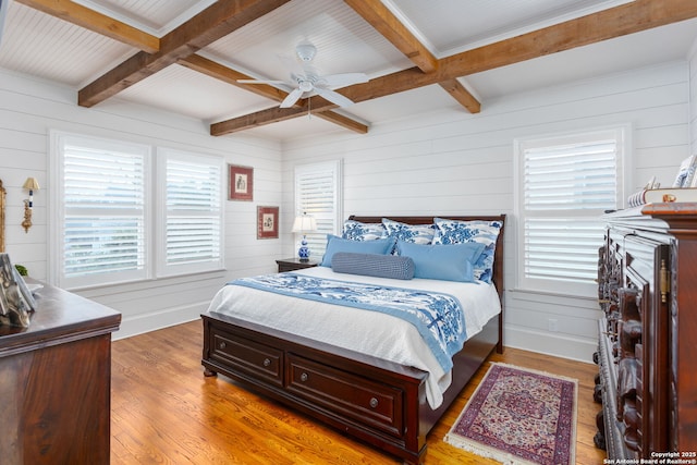 bedroom featuring coffered ceiling, hardwood / wood-style floors, beam ceiling, and ceiling fan