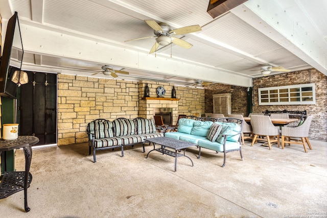 view of patio featuring ceiling fan and an outdoor living space with a fireplace