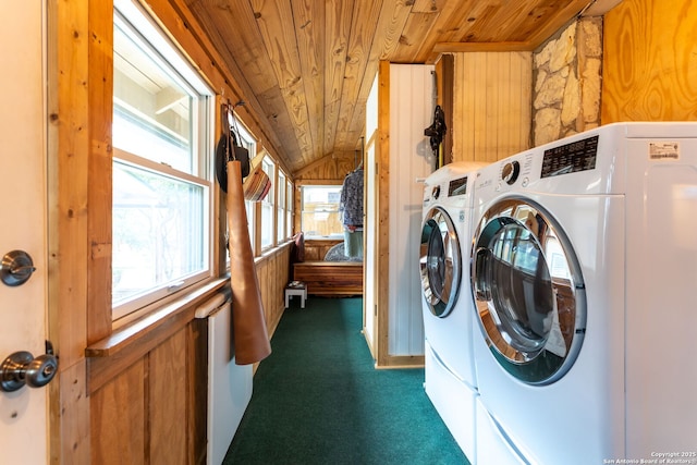 washroom featuring separate washer and dryer, dark carpet, wood ceiling, and wood walls