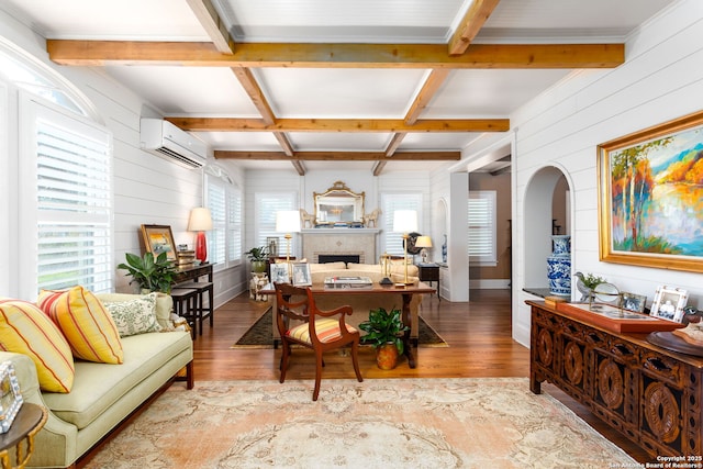 office space with wooden walls, a wall unit AC, coffered ceiling, light hardwood / wood-style floors, and beam ceiling