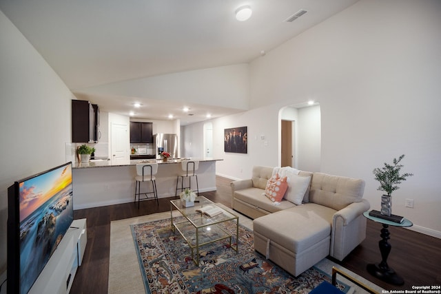 living room featuring dark hardwood / wood-style flooring and high vaulted ceiling