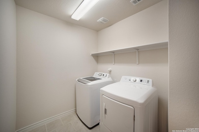 laundry area featuring light tile patterned floors and washing machine and dryer