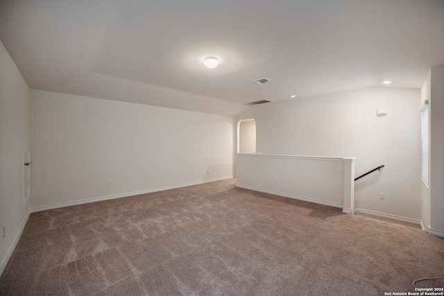 carpeted spare room with vaulted ceiling