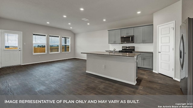 kitchen with appliances with stainless steel finishes, a kitchen island with sink, gray cabinetry, and dark wood-type flooring