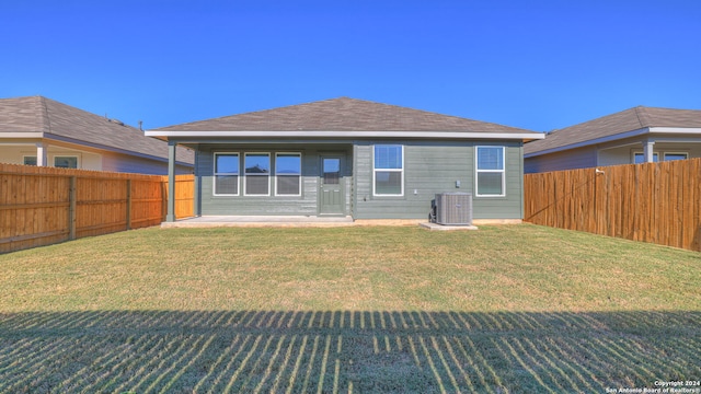 back of house featuring cooling unit and a yard