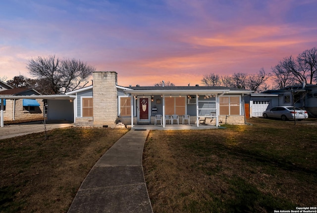 view of front facade with a garage, a lawn, and a porch