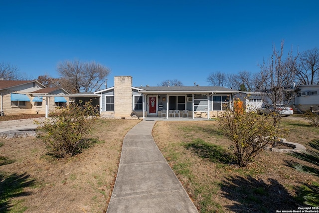 ranch-style home featuring a porch and a front lawn