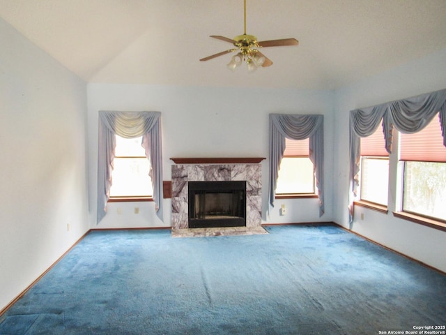 unfurnished living room with lofted ceiling, a high end fireplace, ceiling fan, and carpet