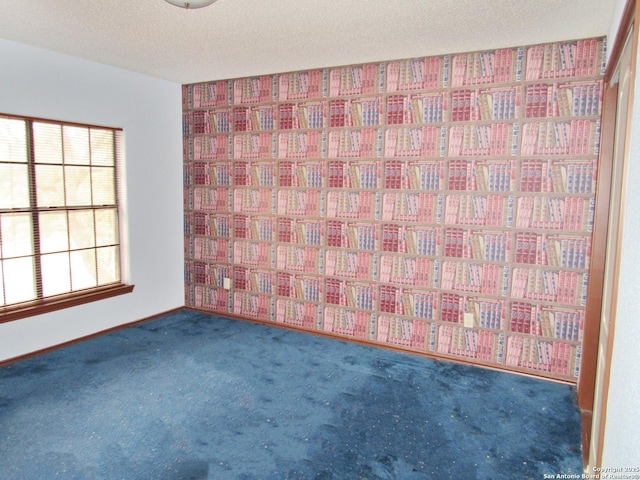 spare room with dark carpet and a textured ceiling