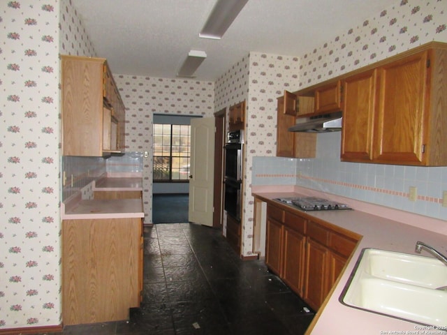 kitchen with tasteful backsplash, appliances with stainless steel finishes, and sink