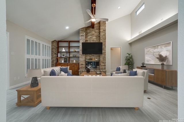 living room with a brick fireplace, high vaulted ceiling, and ceiling fan