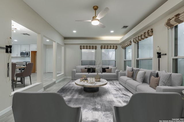 living room featuring ceiling fan and light hardwood / wood-style flooring