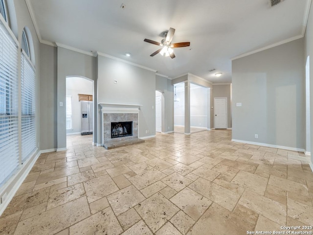 unfurnished living room with ornamental molding, a tile fireplace, and ceiling fan