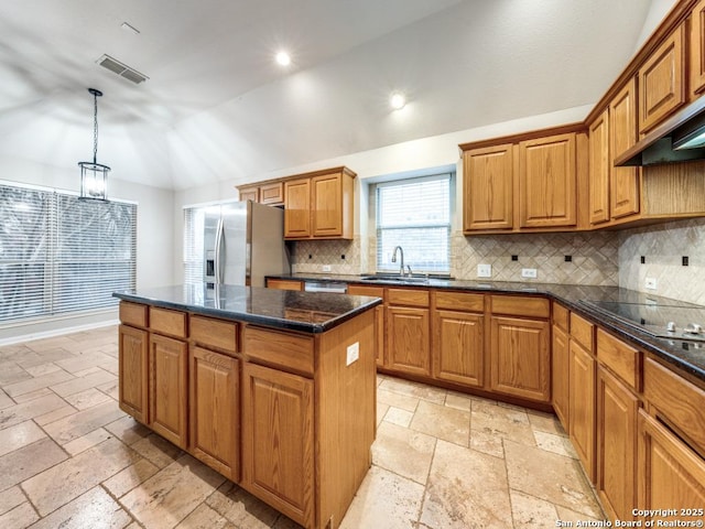 kitchen with lofted ceiling, sink, a center island, hanging light fixtures, and appliances with stainless steel finishes