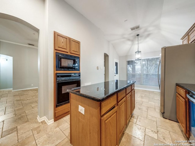 kitchen featuring decorative light fixtures, lofted ceiling, dark stone counters, a center island, and black appliances