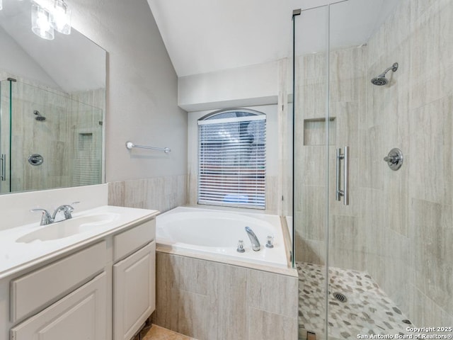 bathroom featuring independent shower and bath, vanity, and lofted ceiling