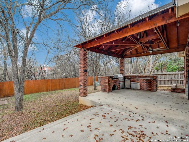 view of patio featuring exterior kitchen, area for grilling, and ceiling fan