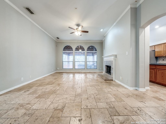 unfurnished living room with ceiling fan, ornamental molding, and a high end fireplace