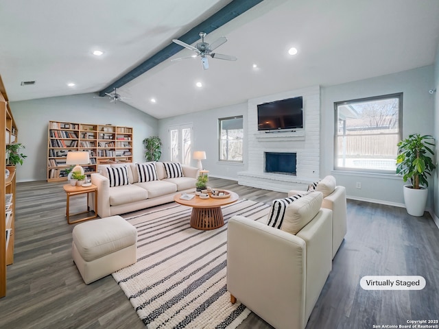 living room with dark wood-type flooring, ceiling fan, lofted ceiling with beams, and a brick fireplace