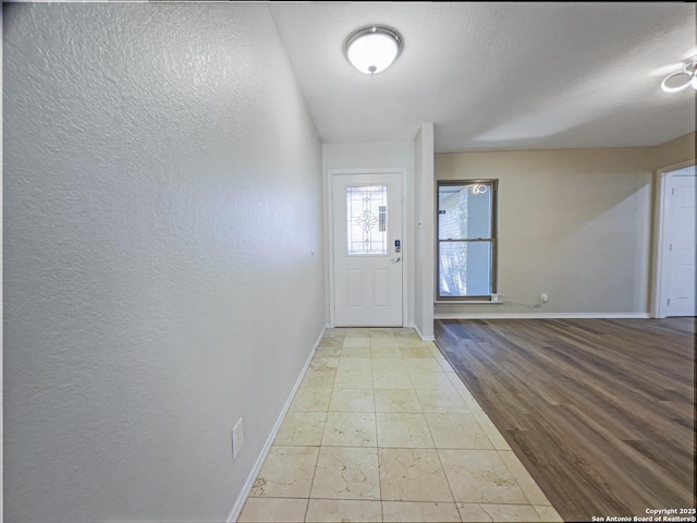 entryway featuring light hardwood / wood-style flooring and a textured ceiling