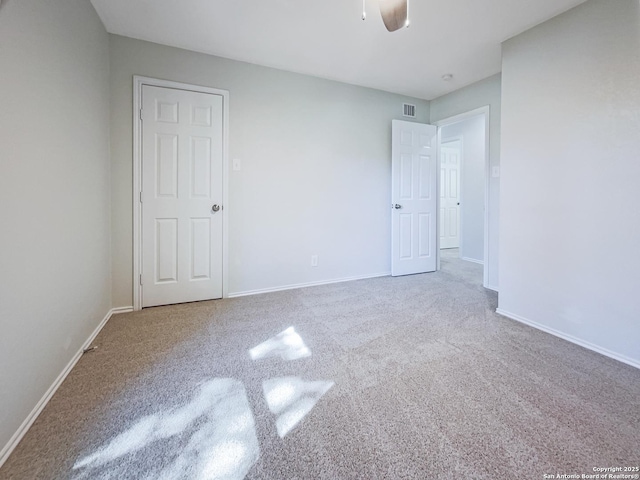 carpeted spare room with ceiling fan