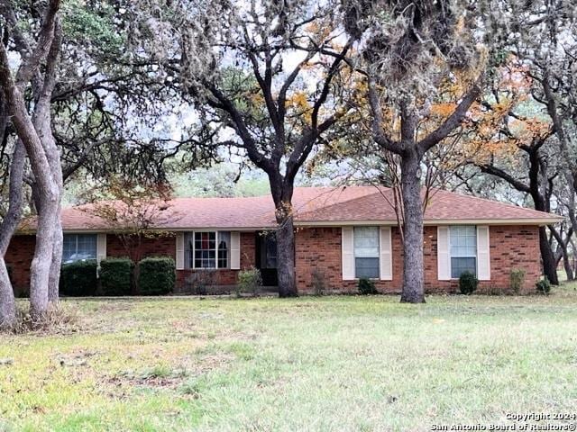 ranch-style home featuring a front lawn