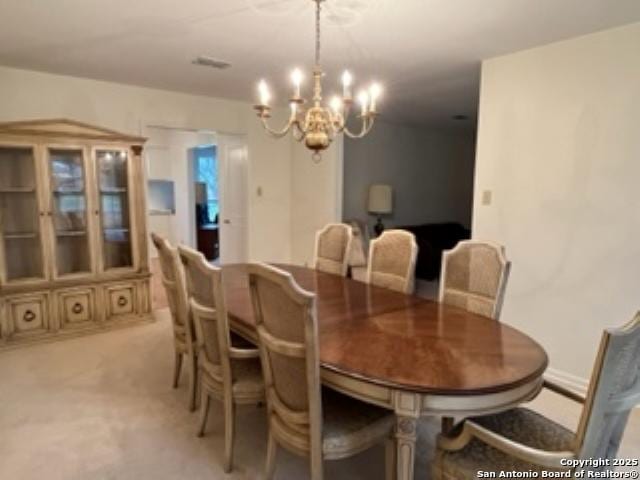 carpeted dining space with a notable chandelier