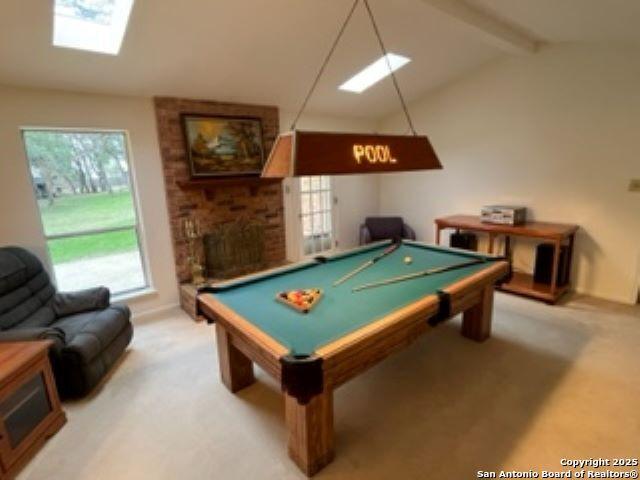 recreation room featuring lofted ceiling with beams, a brick fireplace, carpet floors, and pool table