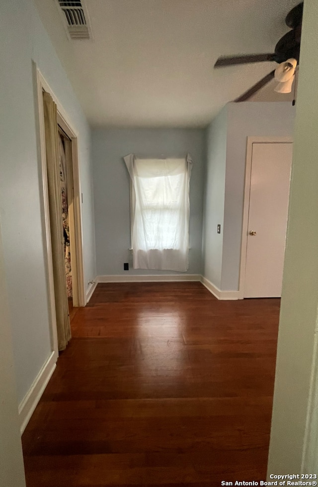 interior space with dark wood-type flooring and ceiling fan