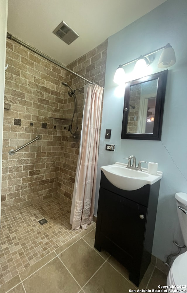 bathroom featuring a shower with curtain, tile patterned floors, toilet, and vanity