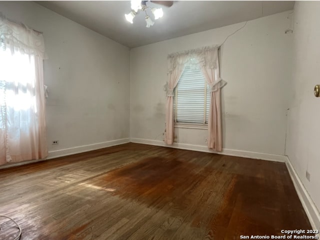 unfurnished room featuring ceiling fan and dark hardwood / wood-style floors