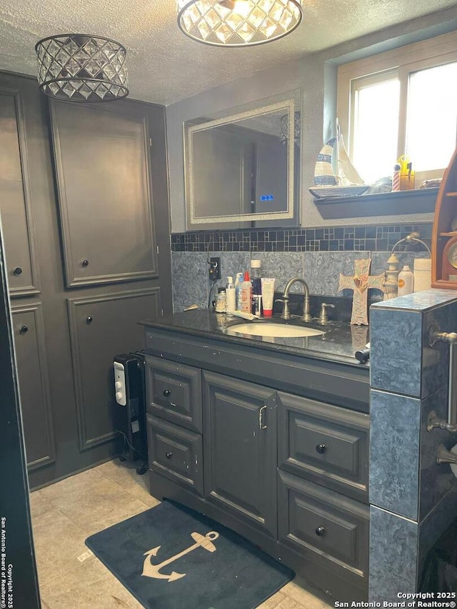 bathroom featuring vanity, backsplash, and a textured ceiling