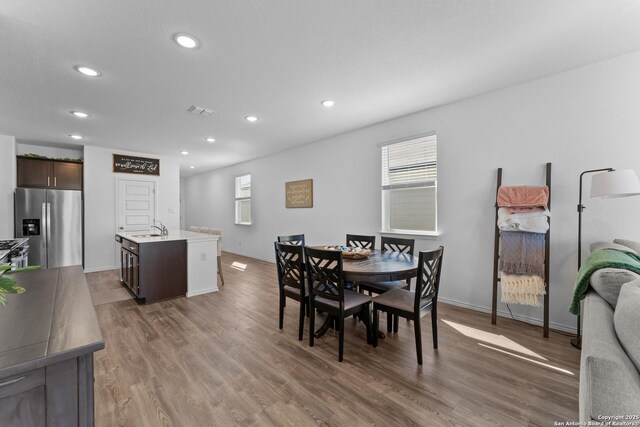 dining space featuring sink and dark wood-type flooring