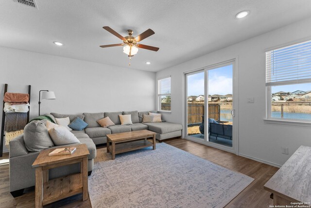 living room with dark wood-type flooring and ceiling fan