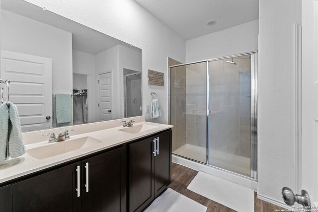 bathroom featuring wood-type flooring, vanity, and a shower with shower door