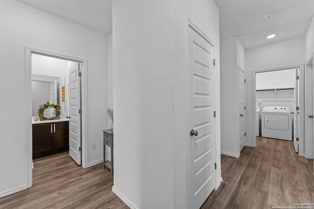 hallway featuring washer and clothes dryer and wood-type flooring