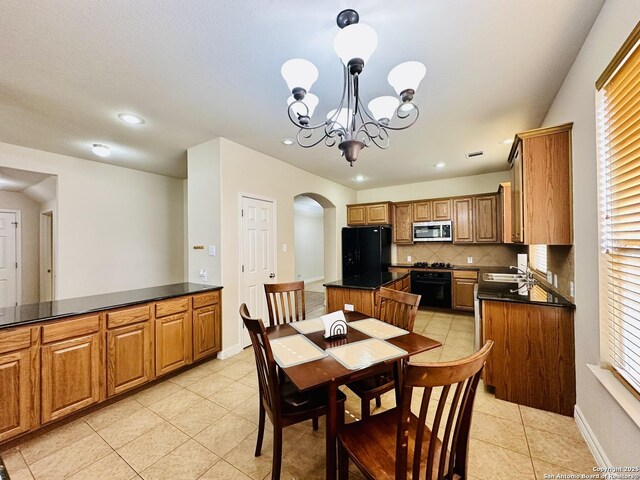 tiled dining room with sink and a notable chandelier